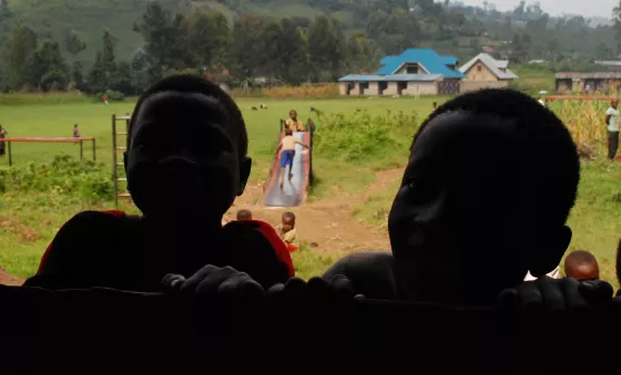 Children peer through window of a school in the DRC.