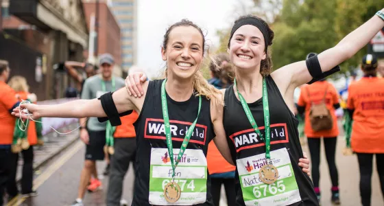 Runners smile after finishing the Royal Parks Half Marathon for War Child.