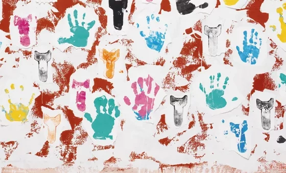 Multicoloured painted hand prints on red background.