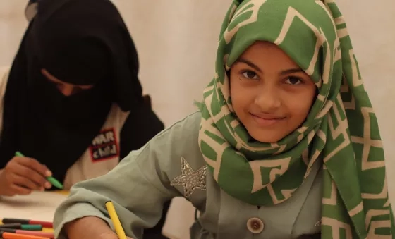 Girl draws pictures at a War Child child-friendly space in a camp in Yemen.