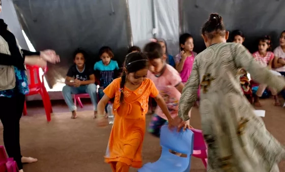 Young girls play a game at a child-friendly space that is run by War Child at a displacement camp in Iraq.