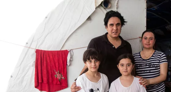 A family in Iraq standing outside their temporay home. 