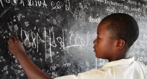 Lamegi drawing on a chalk board in DRC. 