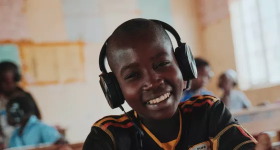 Boy smiling in classroom, Uganda. 