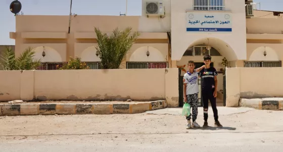 Ali and his friend standing outside of a War Child safe space.