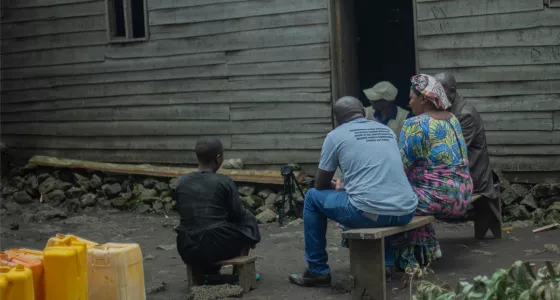 A family sat outside their house in DRC.