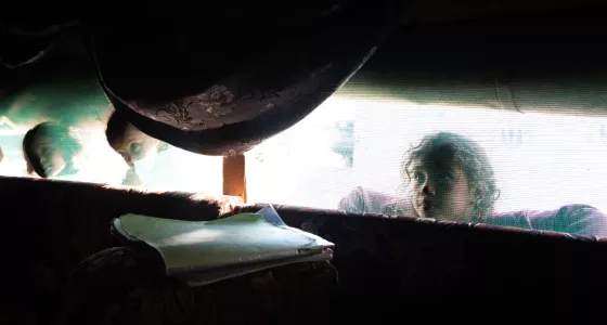 A girl looking through a window.