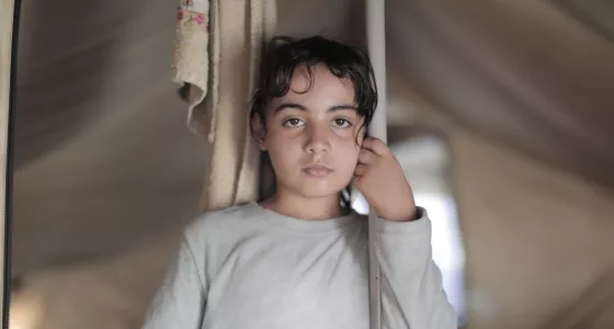 girl in tent stares into camera