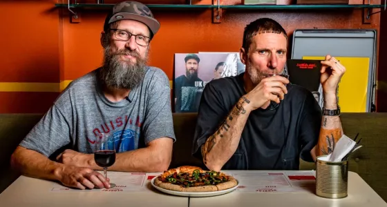 Sleaford Mods members drinking wine and eating pizza