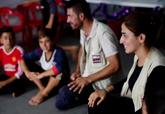 War Child staff member plays games with children in child-friendly space in Iraq.