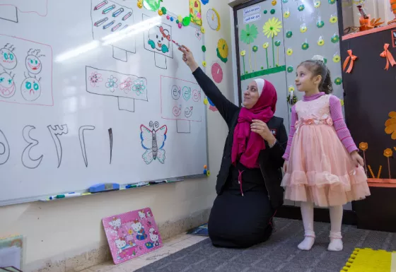 Education facilitator in Jordan teaching students in a War Child temporary learning space.