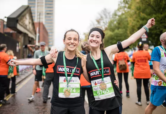 Two Team War Child runners pose with their medals after completing their race. 