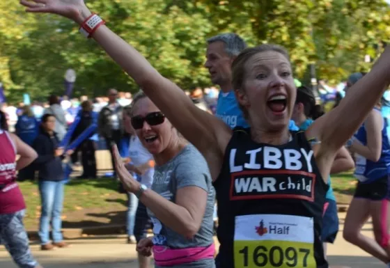 Team War Child runner Libby celebrates whilst running the Royal Parks Half