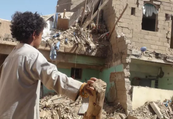 A young boy looks on at the destruction caused by bombs dropped in his local area in Yemen.