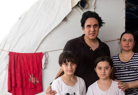 A family in Iraq standing outside their temporay home. 