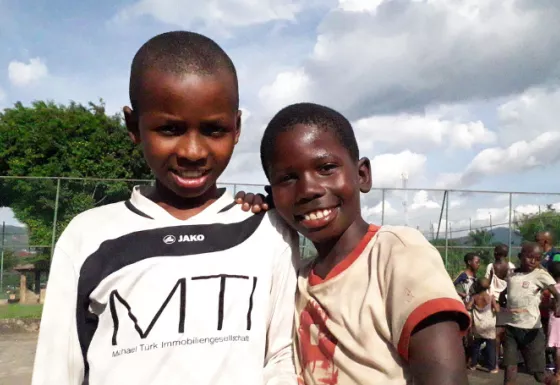 Two boys smiling at a Team Up programme in Burundi. 