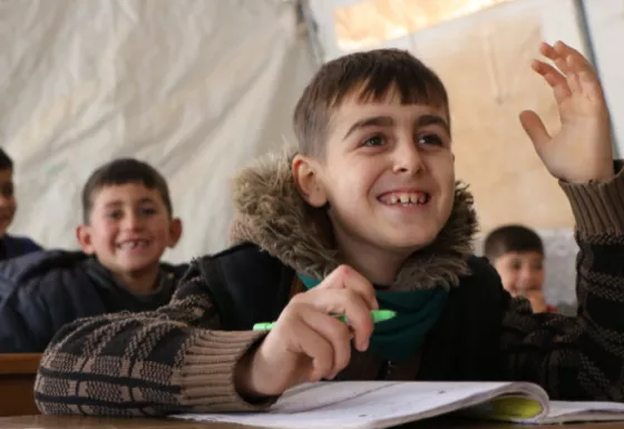 A child smiling whilst in a War Child classroom in Syria. 