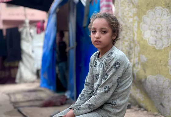 Girl sitting outside in a refugee camp in Gaza.