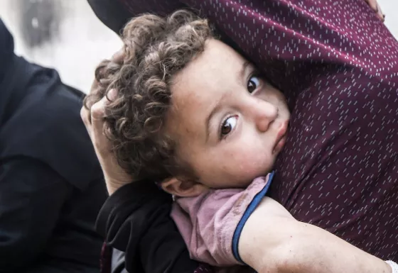 A child being carried by their mother.
