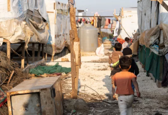 A group of boys walking through a refugee camp in Syria. 