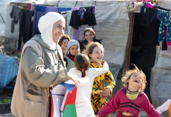 A member of War Child staff with children at a camp in Syria.
