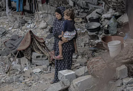 Mother holding child in Gaza amongst rubble