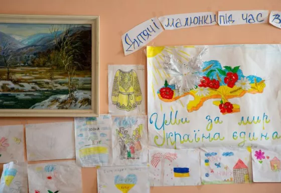Various drawings by children pinned up on a wall.