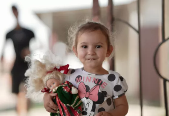 A young girl holding a doll.