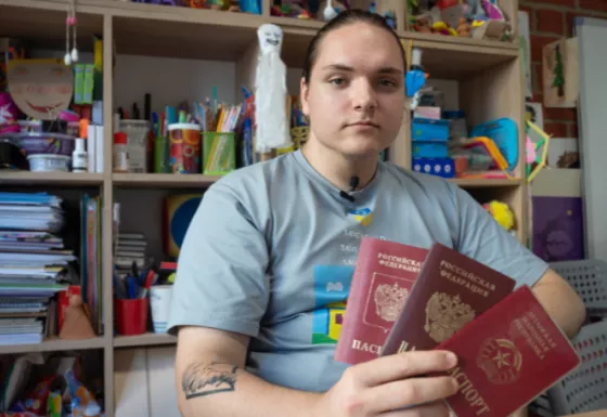 Ivan sat in a classroom holding 3 passports.