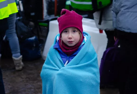 A child in Ukraine wrapped in a blanket.