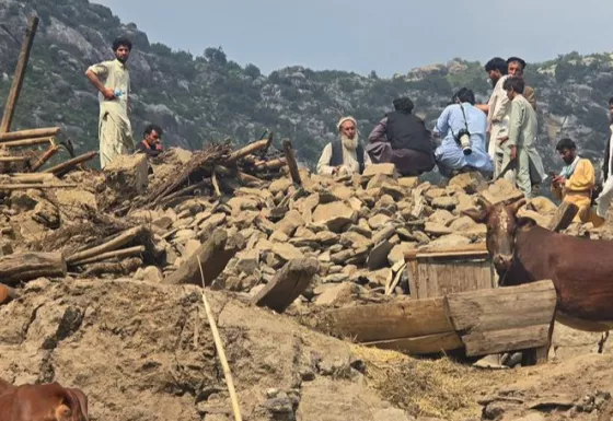 Afghan standing on top of broken homes