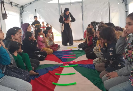 Kids sat in two sets of rows with toys 