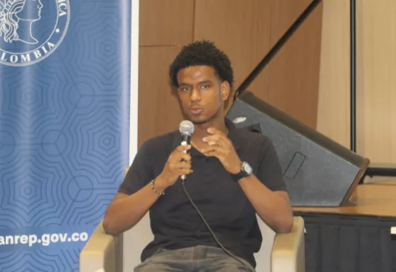 Young adolescent boy speaking into microphone.