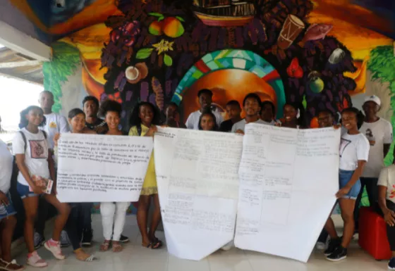 VoiceMore Colombia group consisting of young people, some holding very large papers with writing.