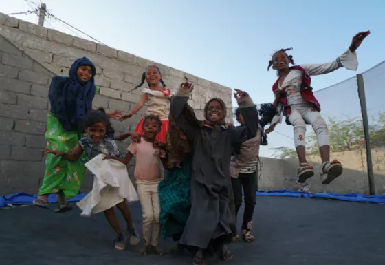7 children jumping on a trampoline 