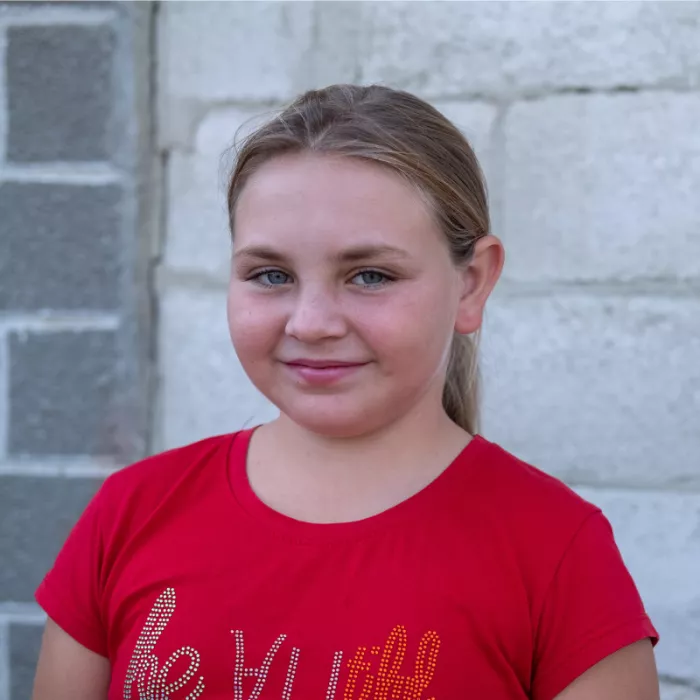 Olga standing in front of a wall. 