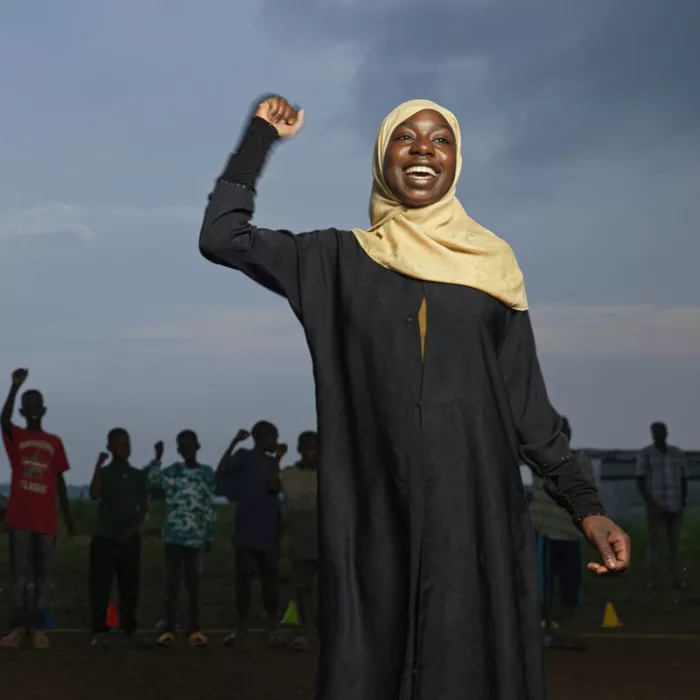 Umomubana smiling with one arm in the air