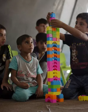 Iraqi boys sit on the floor playing with building blocks together in a War Child child-friendly centre in Iraq.