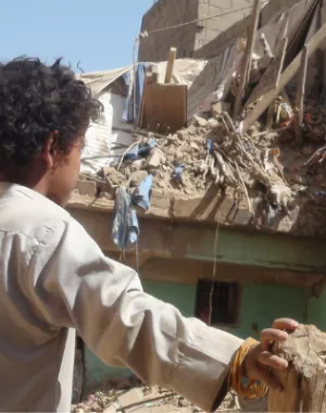 Yemeni child looks at the destruction caused to his village by conflict.