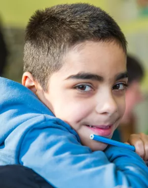 A boy smiling in a classroom in Ukraine. 